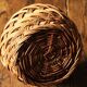 Round woven dark wicker basket with openwork vintage handle