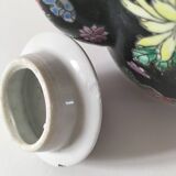 Vintage Chinese teapot with floral polychrome decoration on a black background.