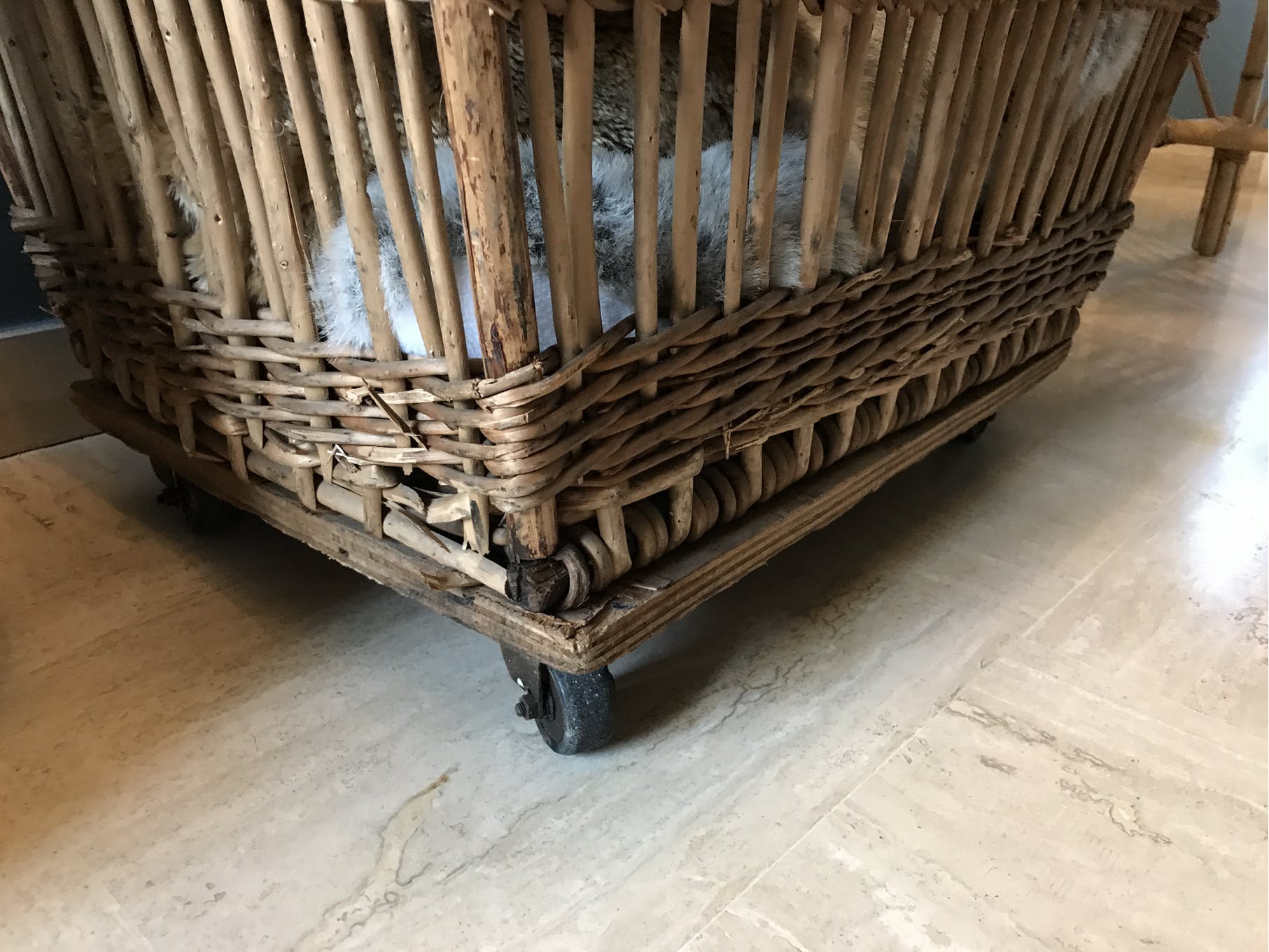 Rattan laundry basket on vintage wheels