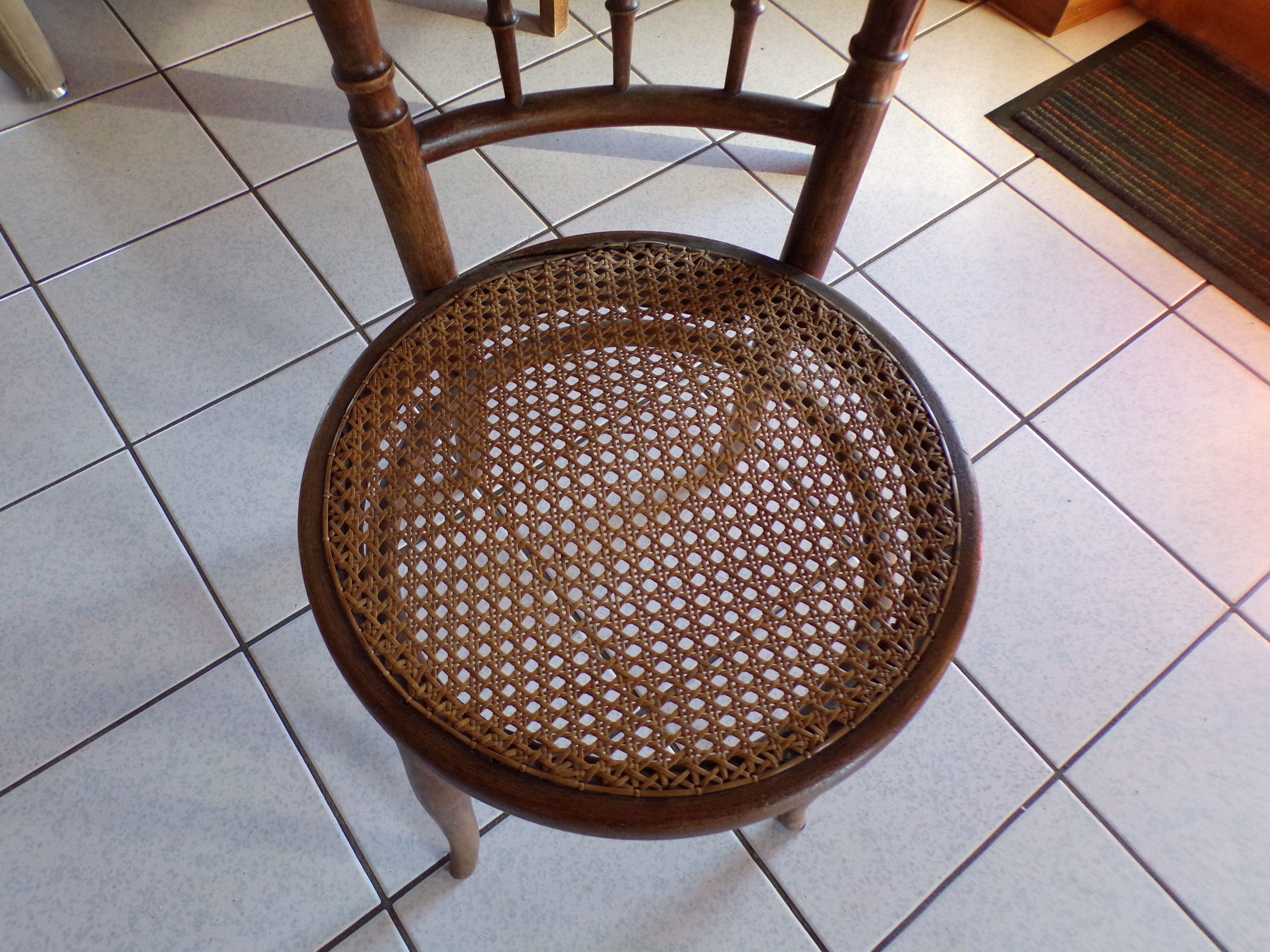 Curved wooden chair, turned and seated in cannage