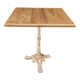 Bistro table with cast iron base and solid teak top