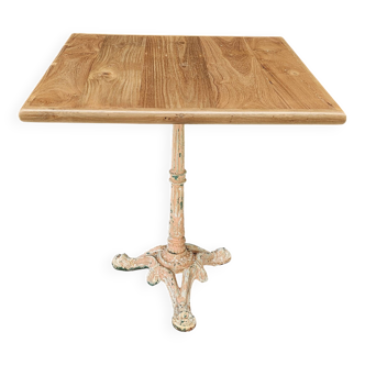 Bistro table with cast iron base and solid teak top