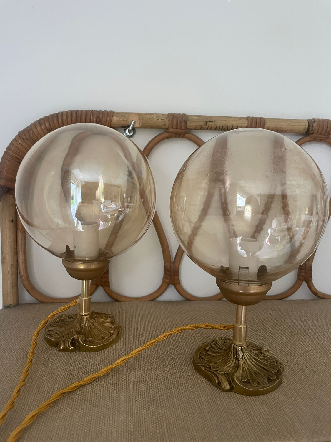 2 bedside lamps with round amber glass globes and gold metal.