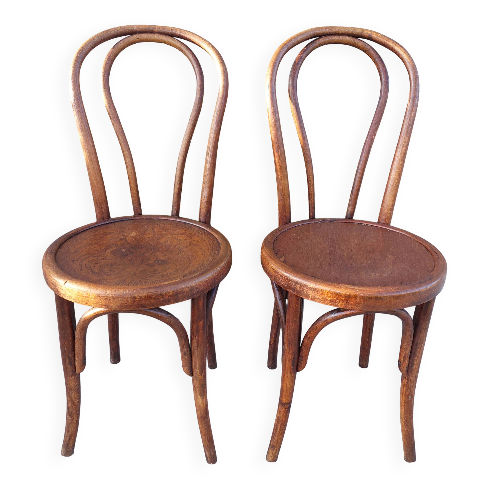 pair of round wooden chairs with a pattern on the seat