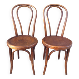 pair of round wooden chairs with a pattern on the seat