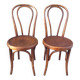 pair of round wooden chairs with a pattern on the seat
