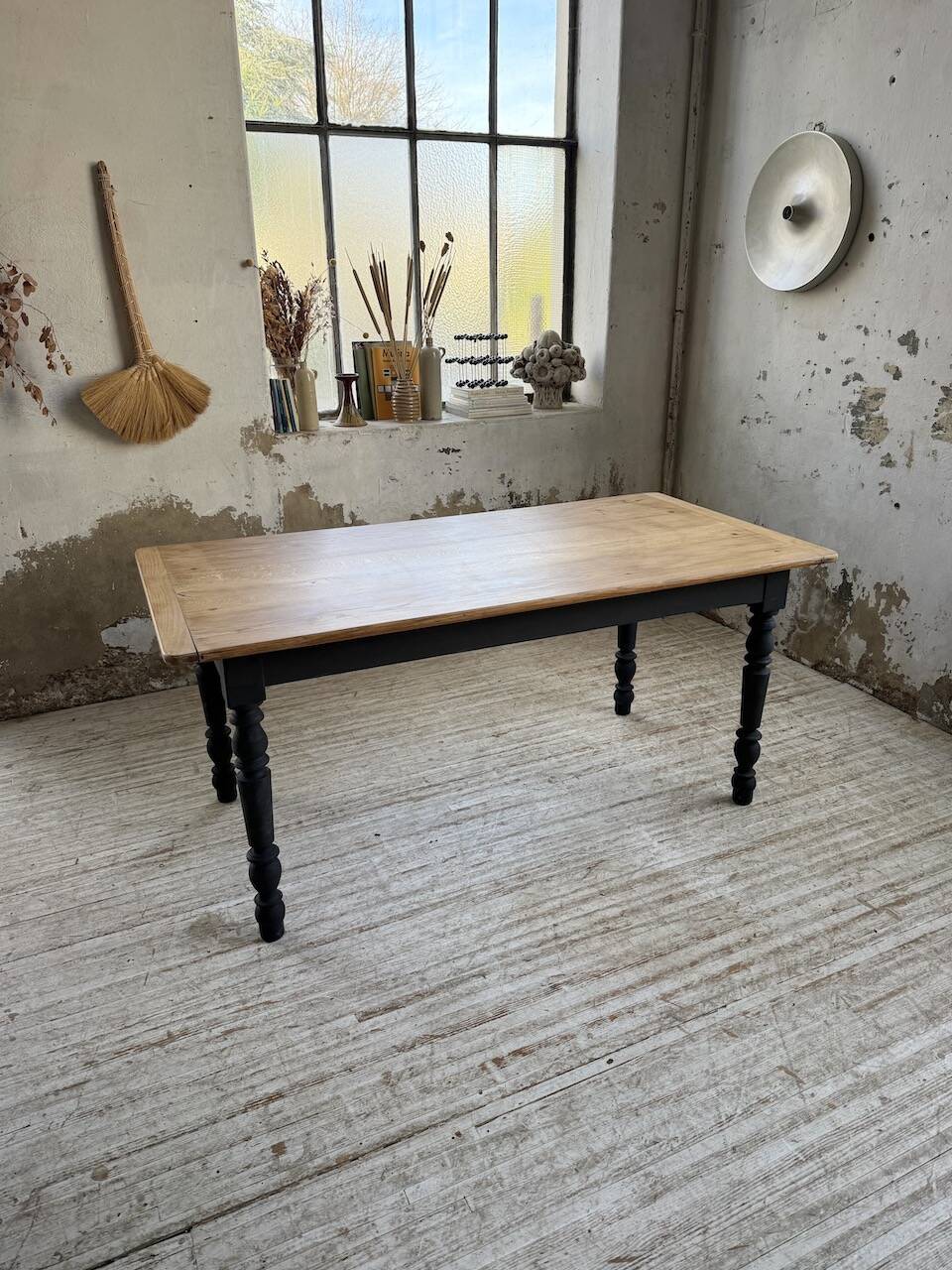 Oak farmhouse table with turned black legs.