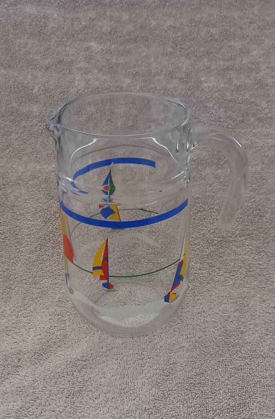 Vintage jug carafe for lemonade and juice, boats by the seaside, France.