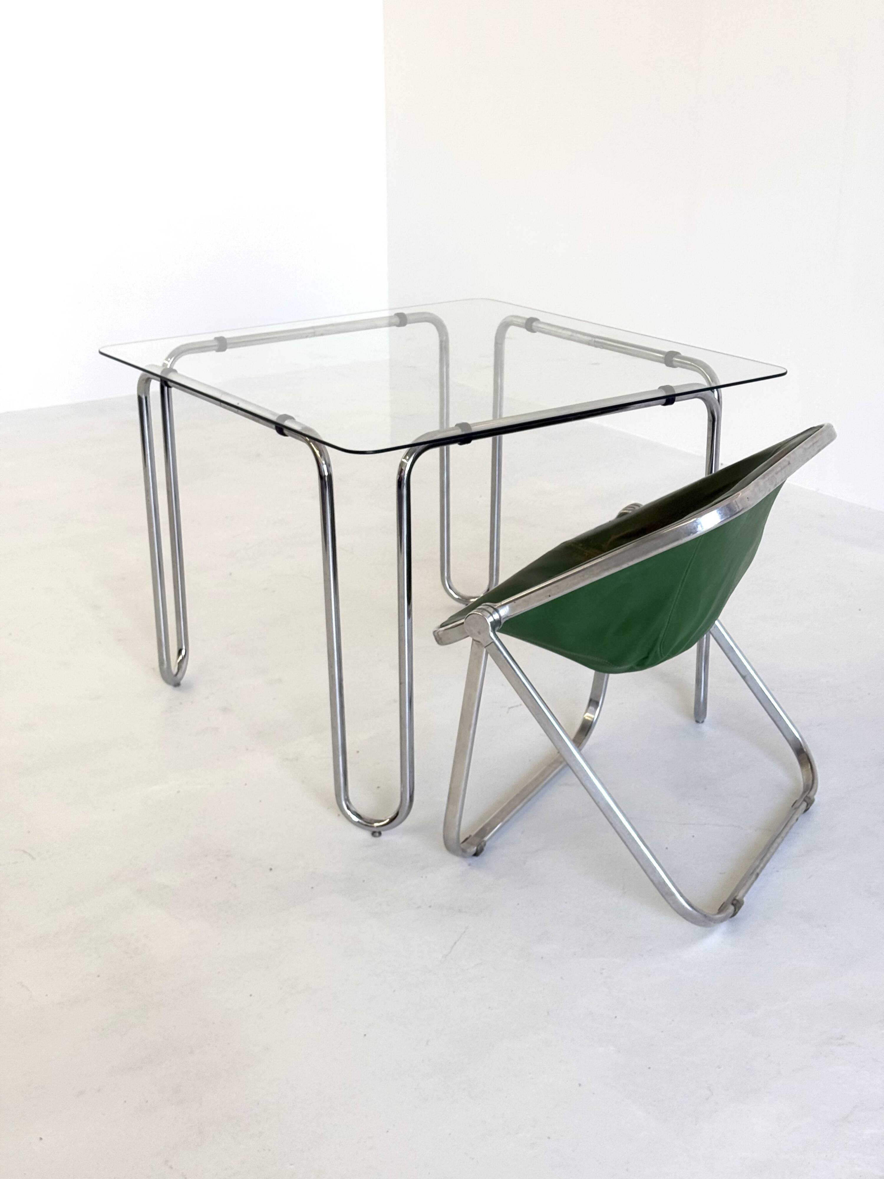 Italian vintage dining table with smooth glass and tubular frame base