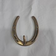 Horseshoe-shaped brass coat rack