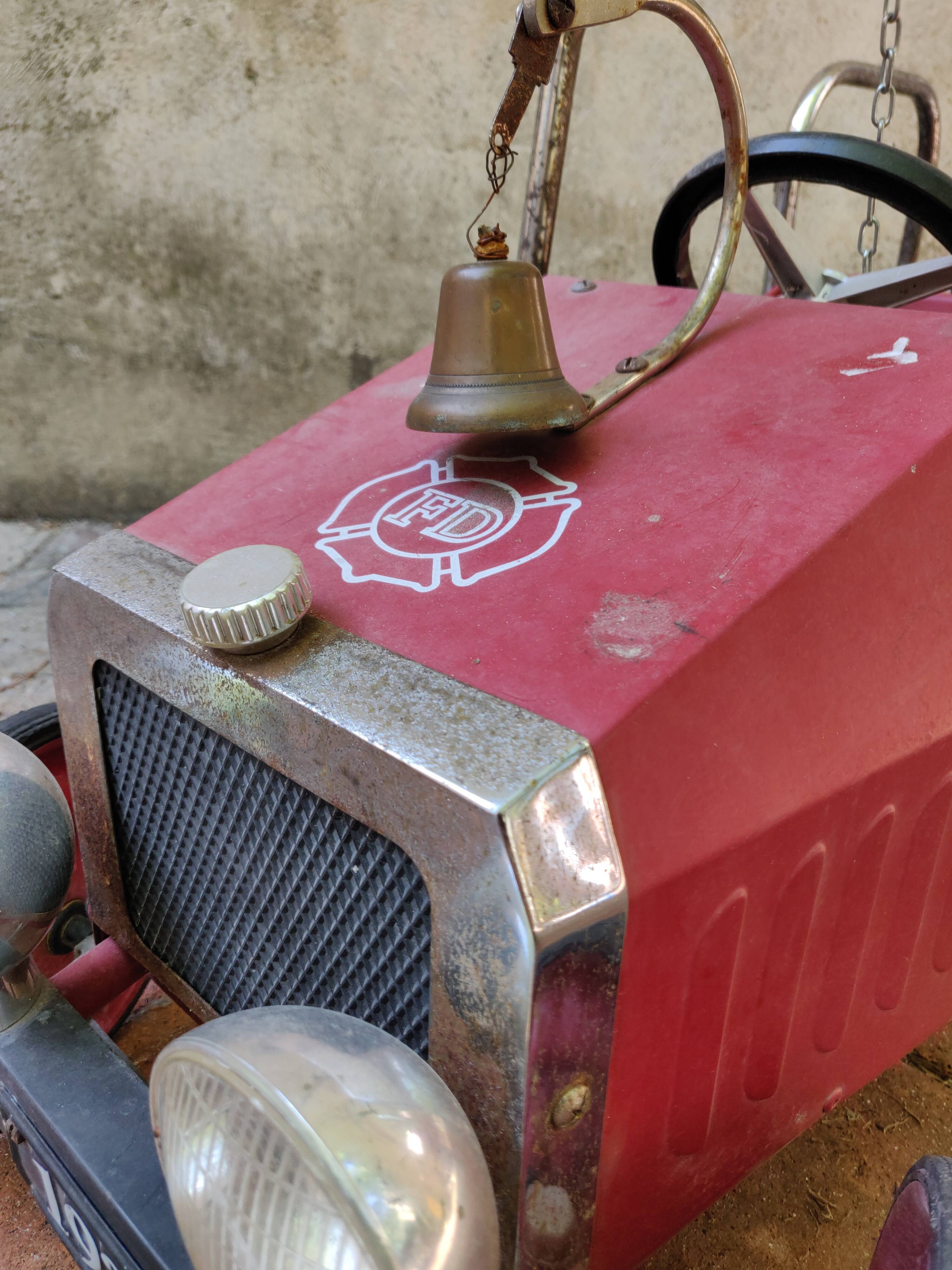 Old pedal car in tole fire truck