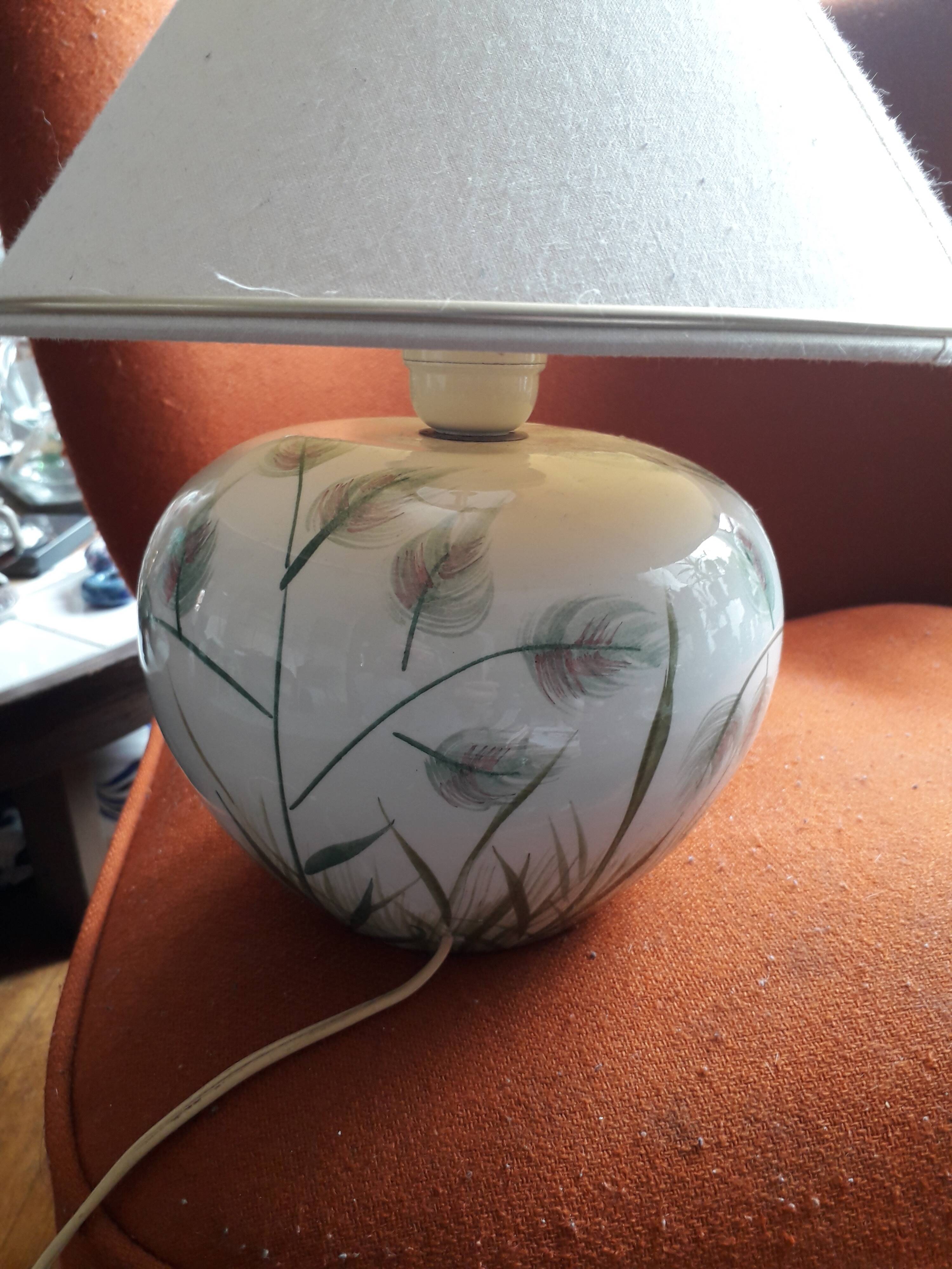 Antique ceramic lamp with a floral design.