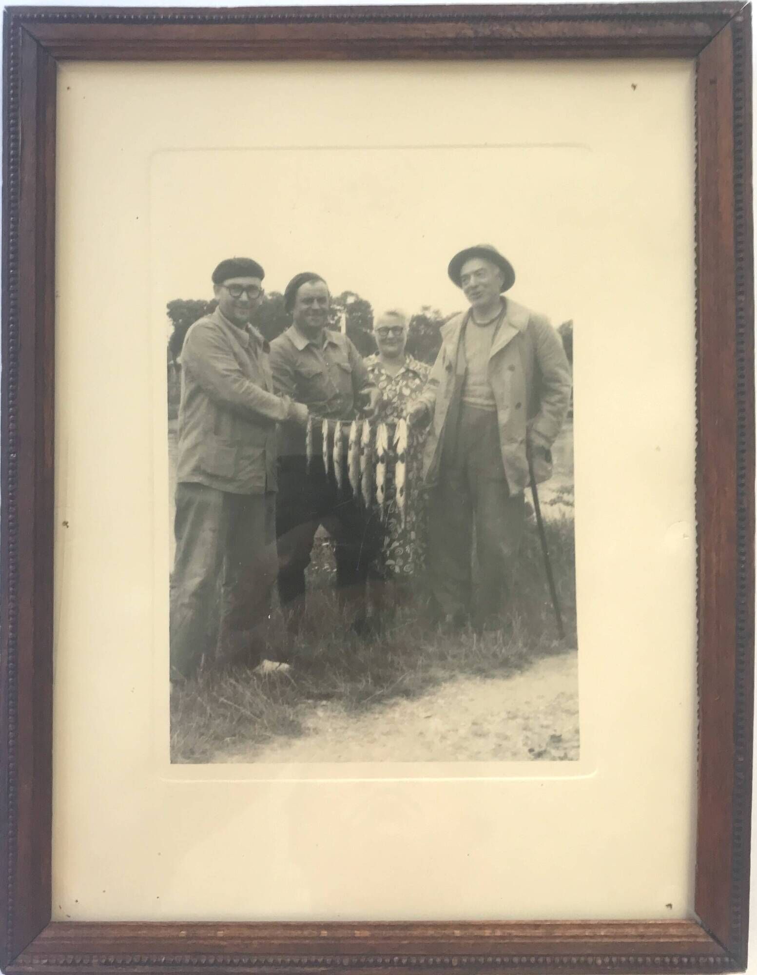 Fishing trophy with radiant faces, c. 1950. Black and white photograph.