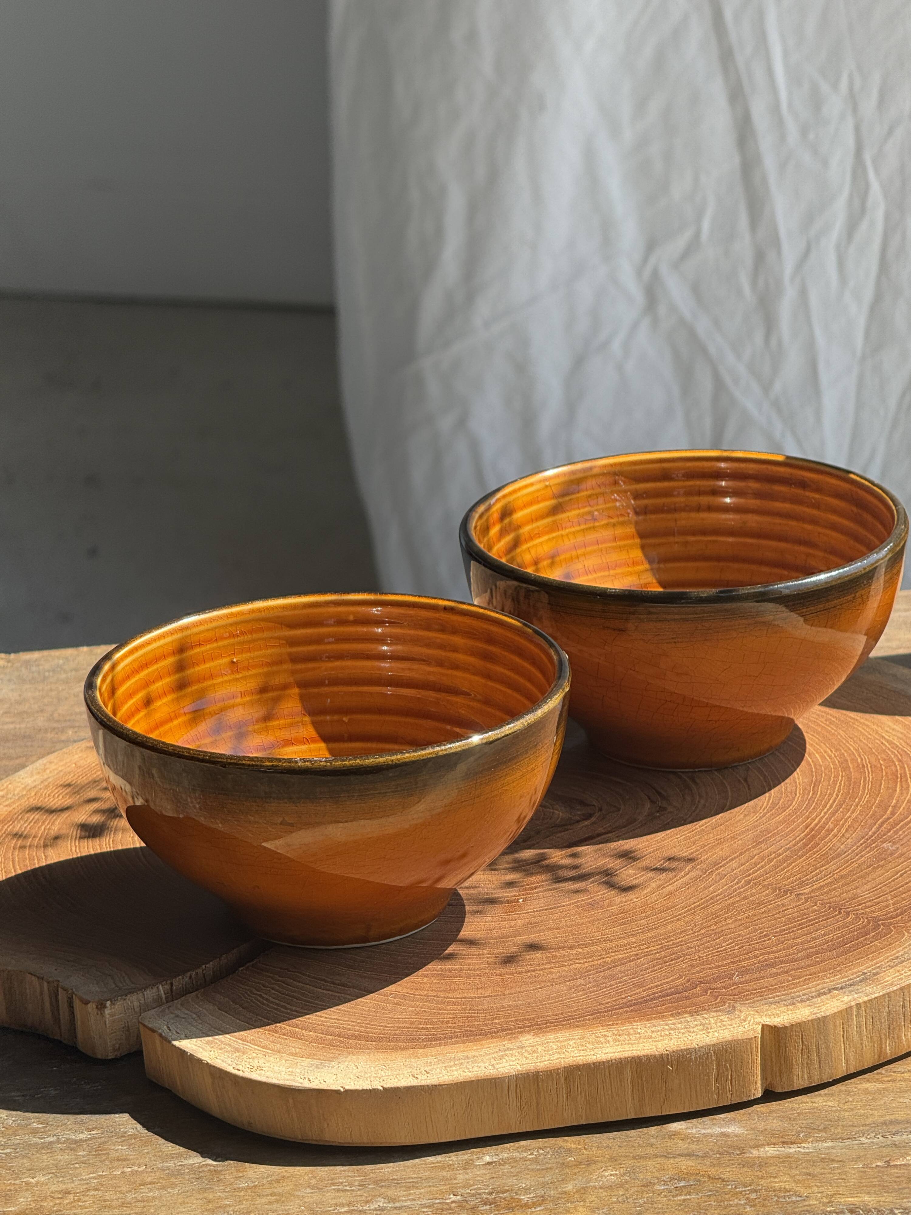 Pair of small orange bowls with black edging