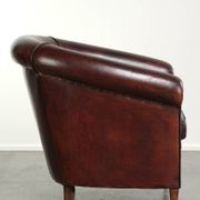 Vintage sheepskin club armchair with decorative nails and black piping
