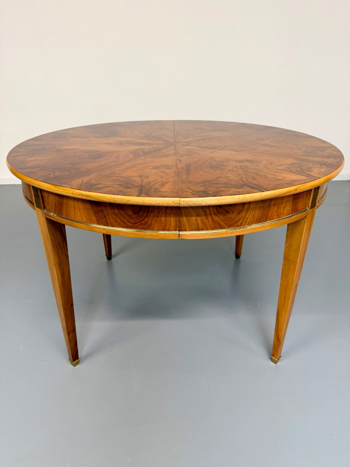 Round walnut Napoleon III extendable table with bronze top in good condition.