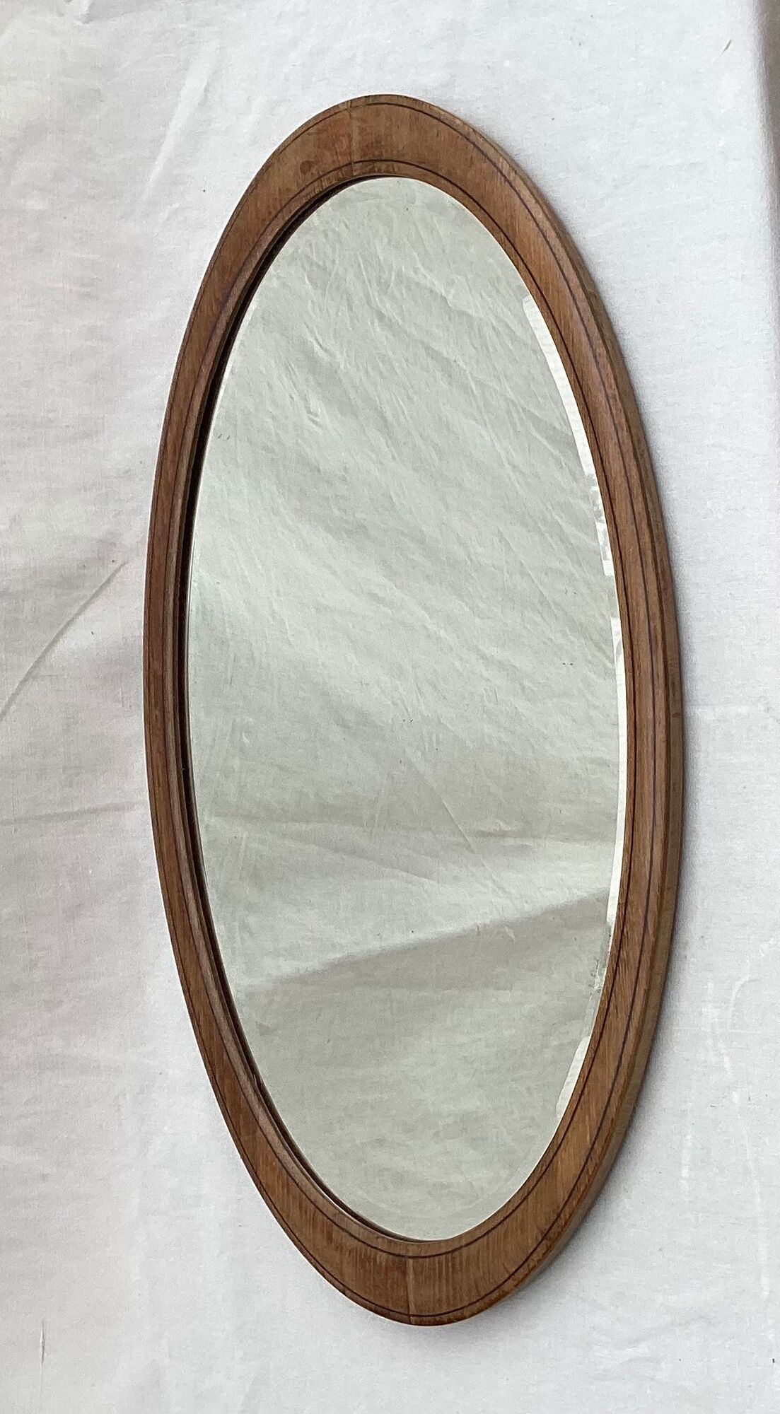 Oval beveled mirror surrounded by light wood dimension: height -74,5cm- width -38,5cm- prof-2cm-