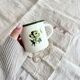 Tasse émaillée vintage beige liseré vert motif branche d'olivier style rustique