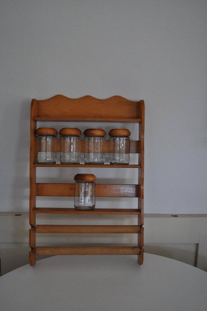 Brown wooden wall spice rack with a set of 6 glass jars, 1950s vintage style.