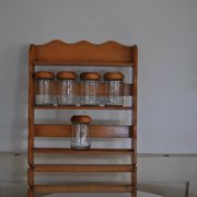 Brown wooden wall spice rack with a set of 6 glass jars, 1950s vintage style.