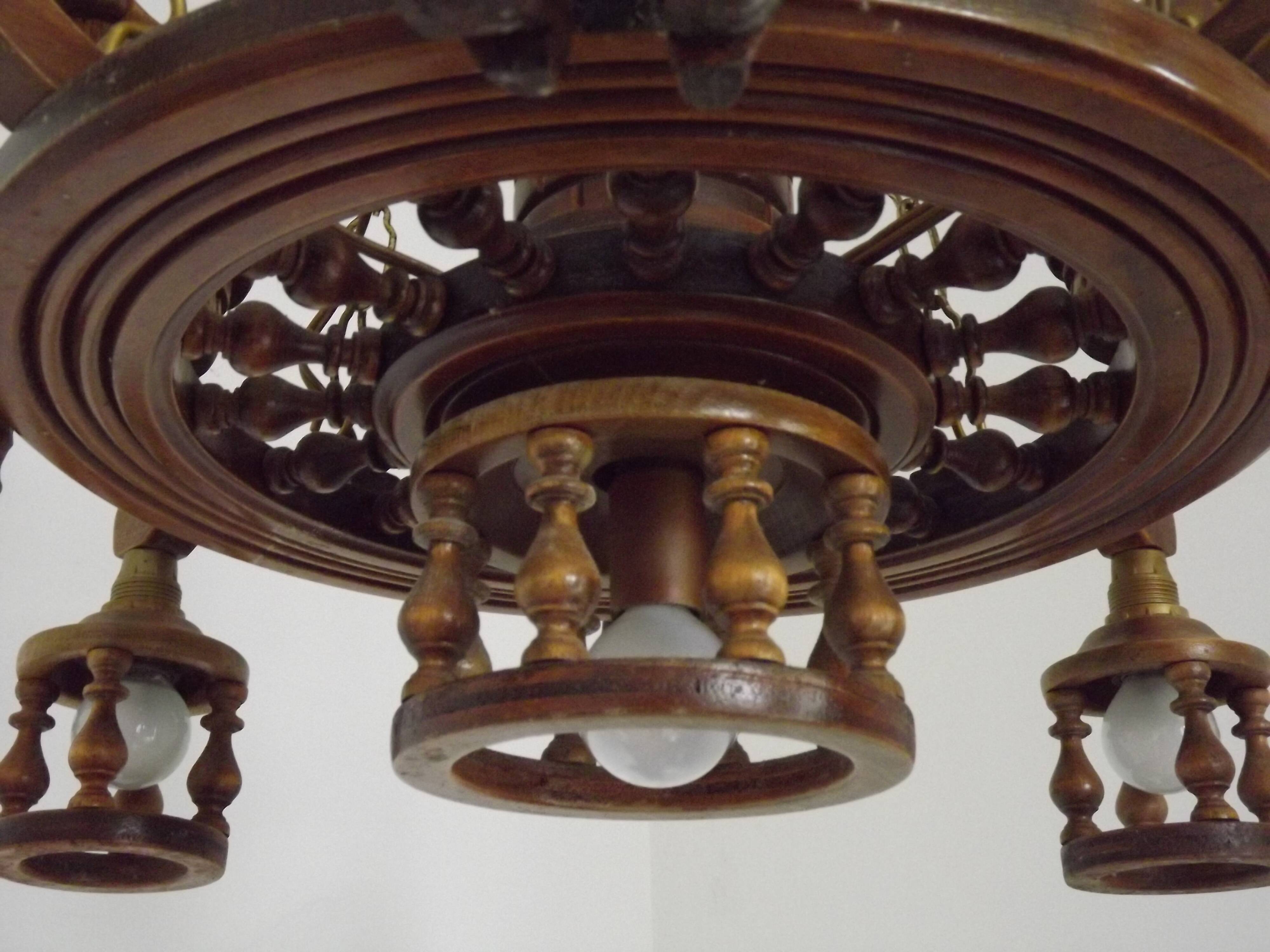 French vintage Breton chandelier with hand-carved figures, well, and lantern lights.