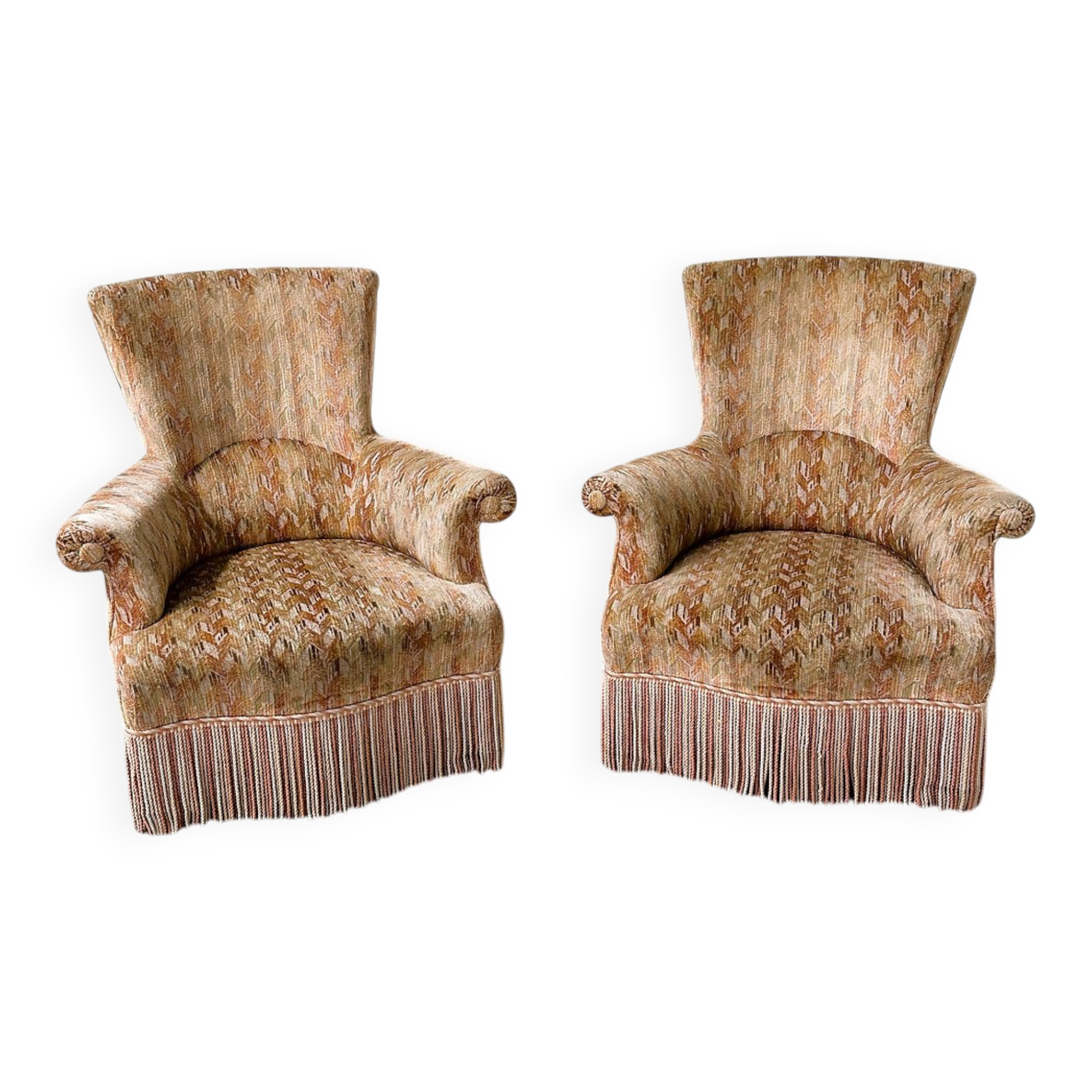 Pair of sculptural Hollywood Regency lounge chairs with original fringed upholstery