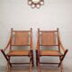 Pair of folding chairs in bamboo and caning, leather and brass