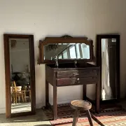 Antique mirror door (left) of a brown oak wardrobe with bevelled glass.