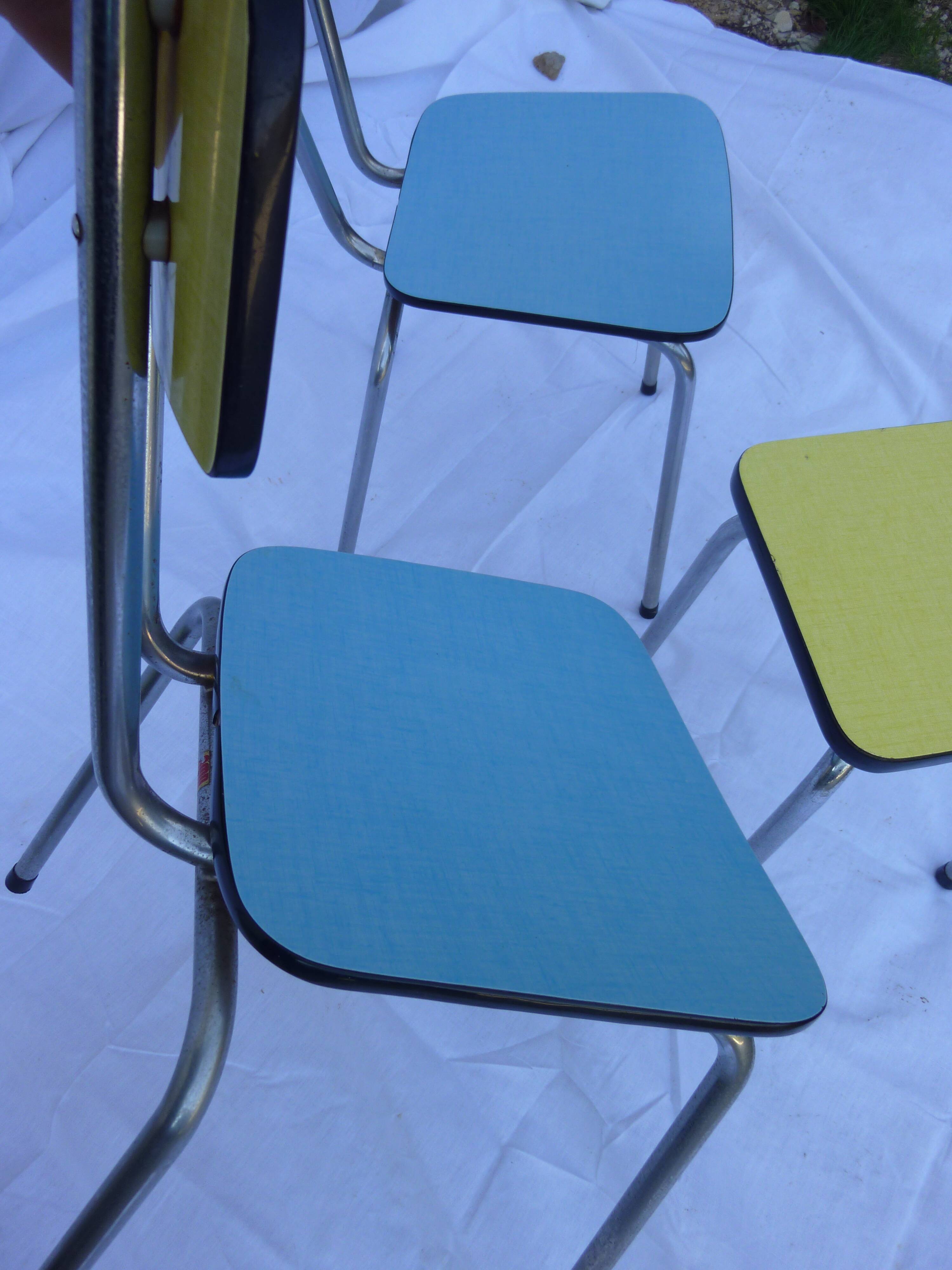 Two chairs and a yellow and blue stool in formica