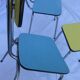 Two chairs and a yellow and blue stool in formica