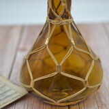 Amber decanter with wicker and golden chain
