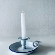 Old candle holder in white enameled metal