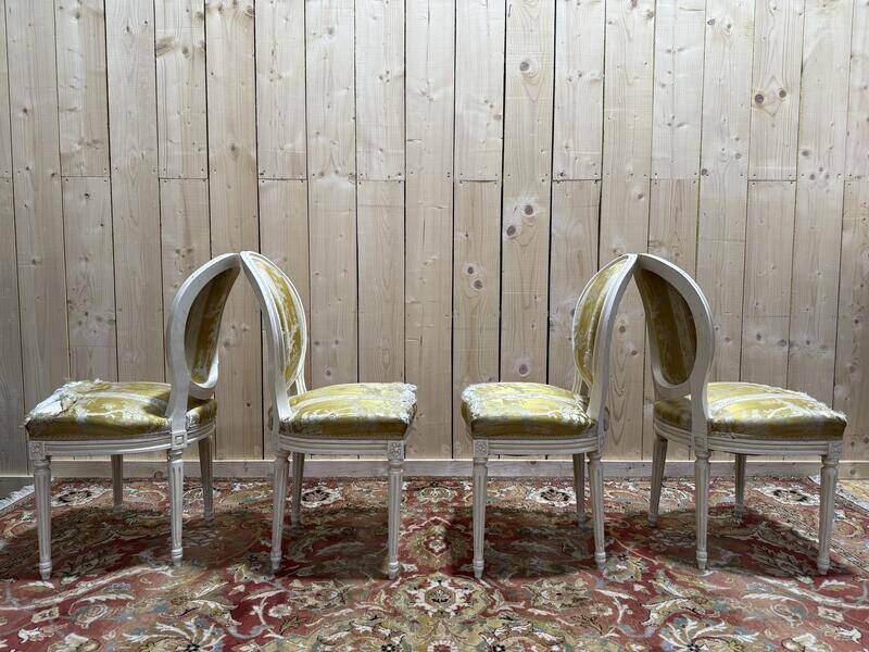 Suite de 4 chaises médaillons de style Louis XVI rechampi blanc cassé