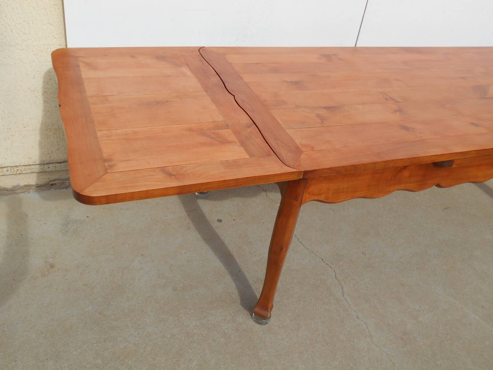 Large solid wood table with integrated extensions.