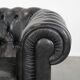Set of a black cowhide leather Chesterfield armchair and matching ottoman