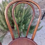 pair of round wooden chairs with a pattern on the seat