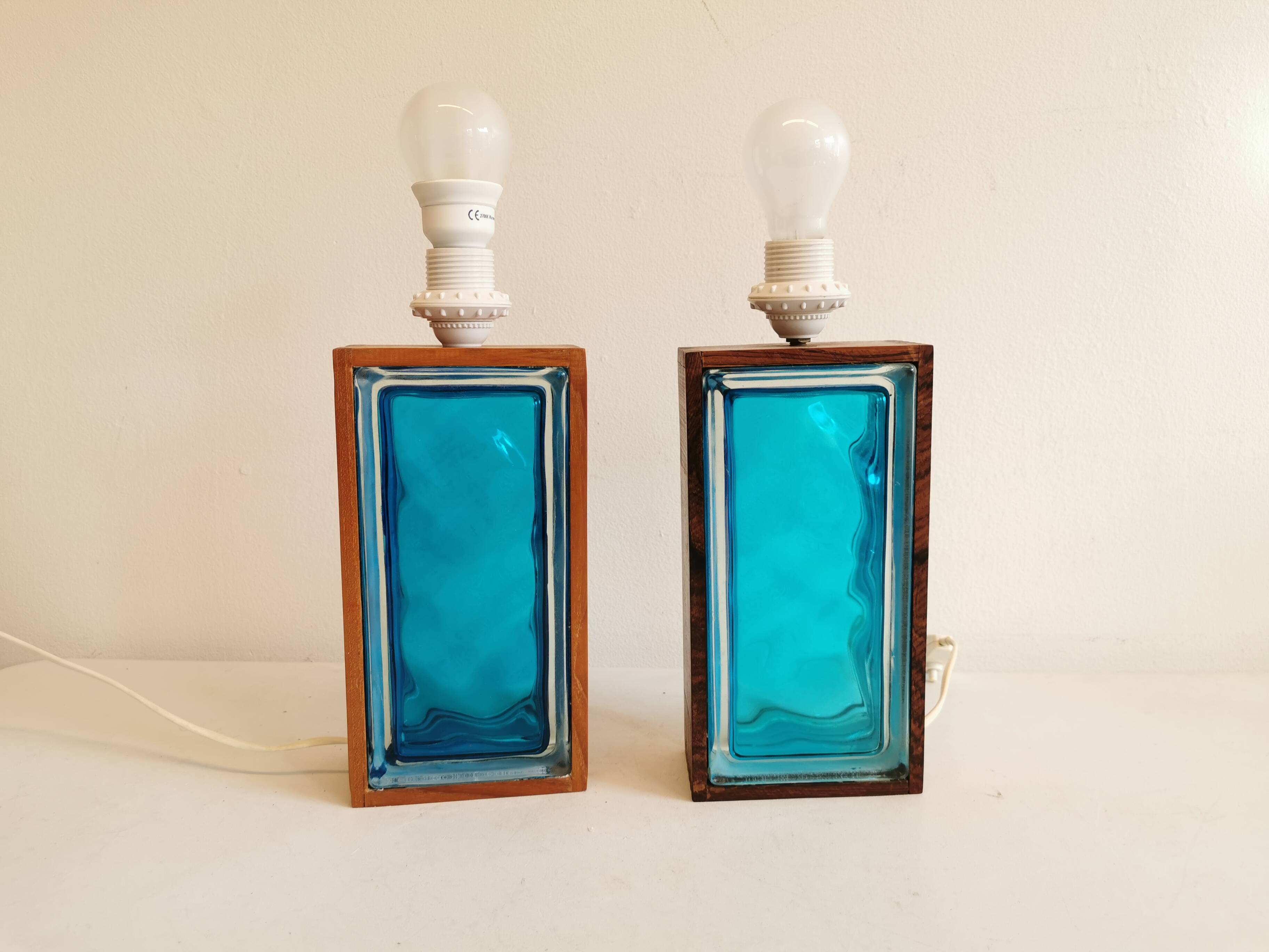 Two Swedish table lamps in solid pressed blue glass and teak wood "frame".