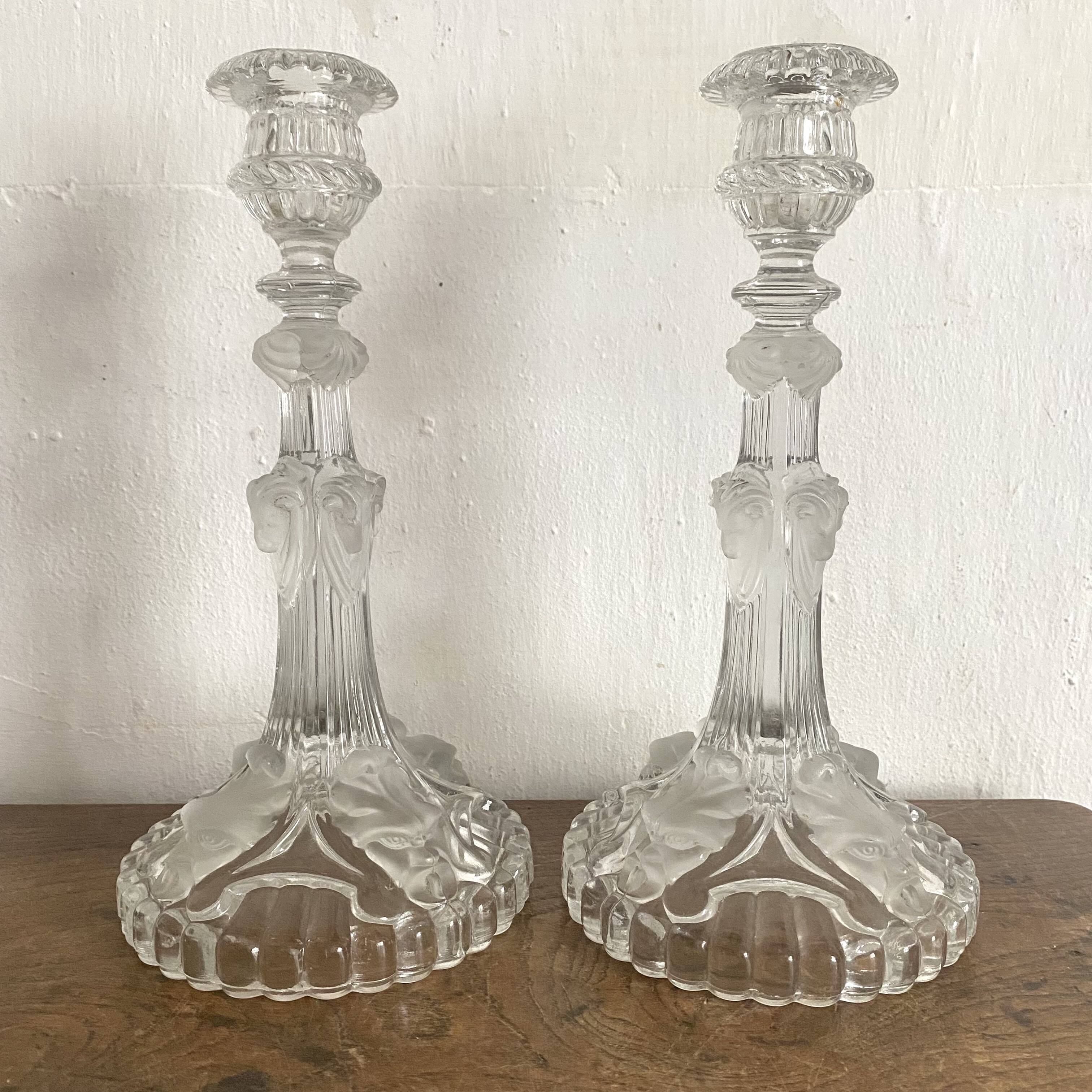 Pair of moulded glass candlesticks, ram heads and masks