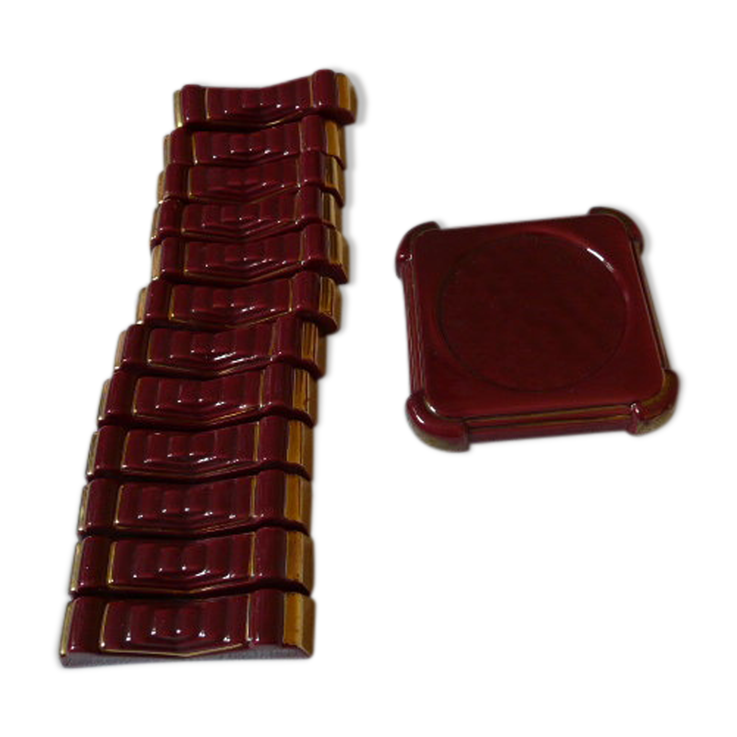 Ensemble 12 porte couteaux et un dessous de bouteille en faïence émaillée rouge
