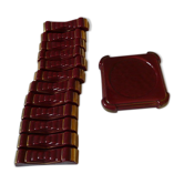 Ensemble 12 porte couteaux et un dessous de bouteille en faïence émaillée rouge