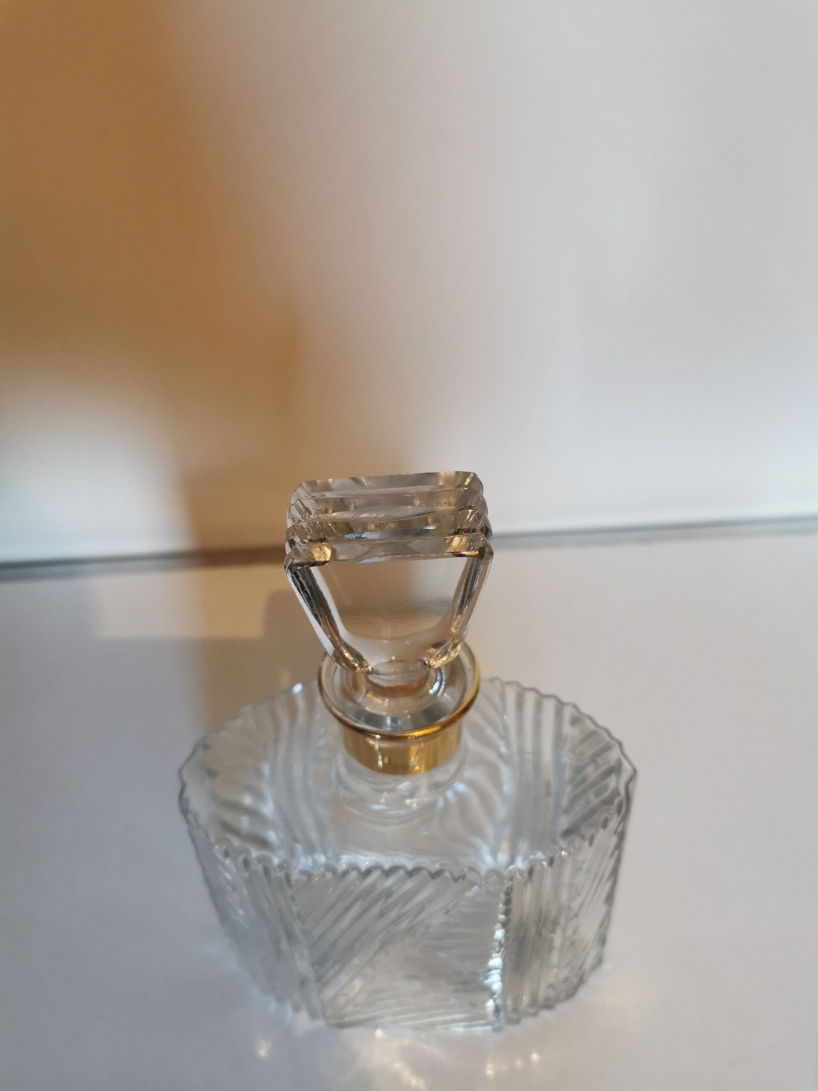 Carved glass decanter, golden band on the collar