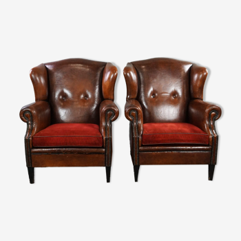 Ensemble de deux fauteuils en cuir de mouton avec coussins rouge