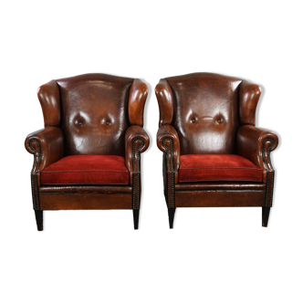 Ensemble de deux fauteuils en cuir de mouton avec coussins rouge