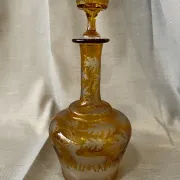Amber bohemian glass liqueur carafe decorated with a stag in the forest.