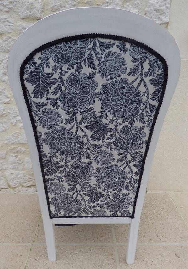 Voltaire style armchair covered in floral fabric in quality aged wood