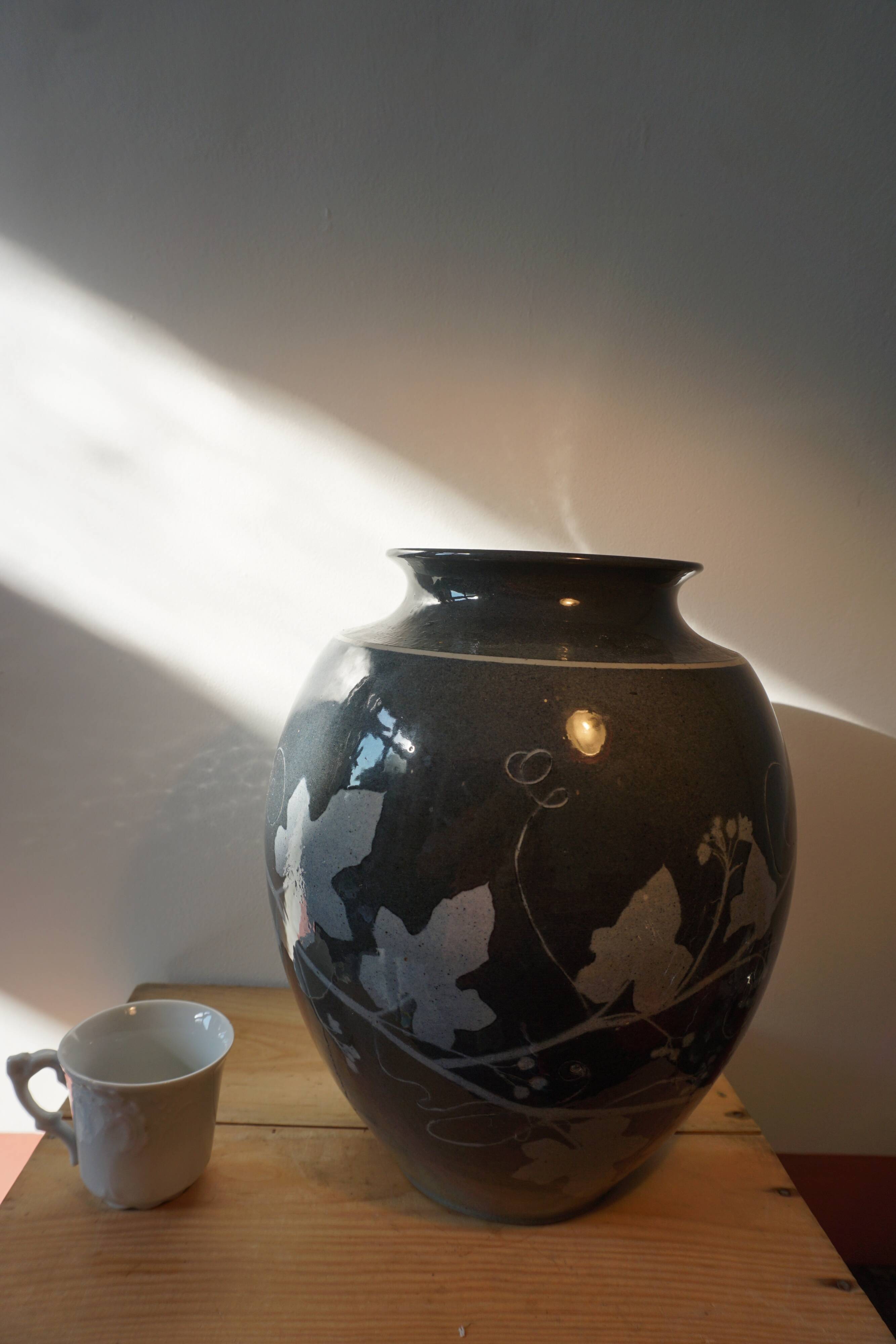 Black vase with plant decoration by Philippe Jacques