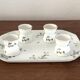 Egg cups on a Limoges porcelain tray by Bernardaud with a barbel decoration.