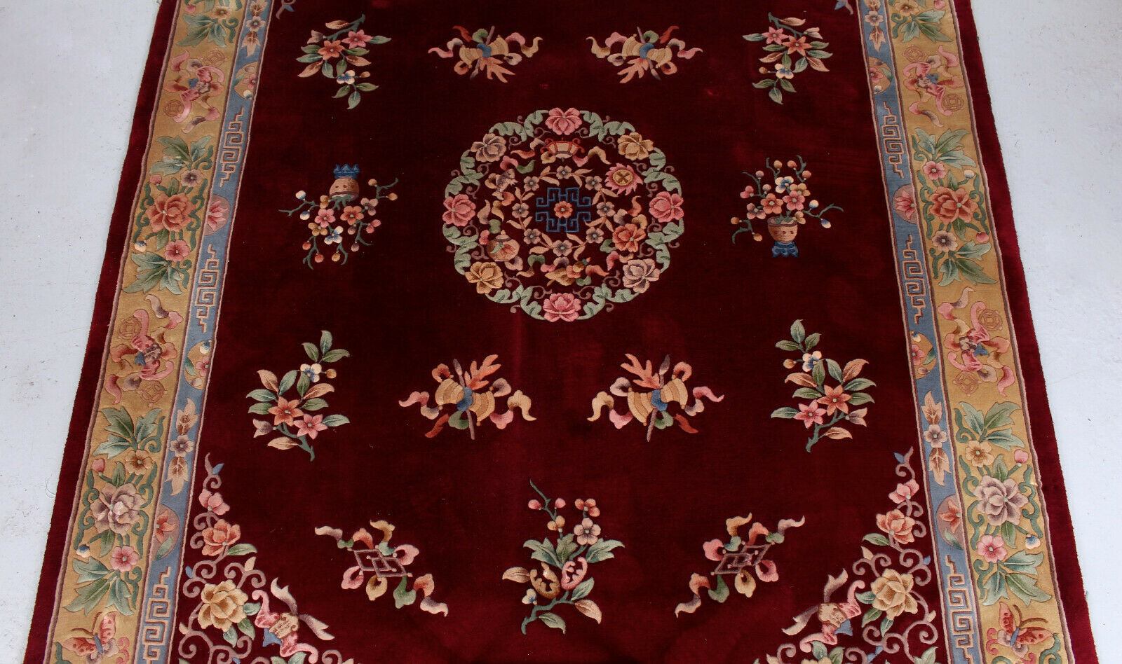 China wool fringed rug with floral pattern on deep plum background 393x274cm