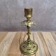 Antique brass candlestick with patina, openwork vintage foliage decoration.