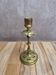 Antique brass candlestick with patina, openwork vintage foliage decoration.